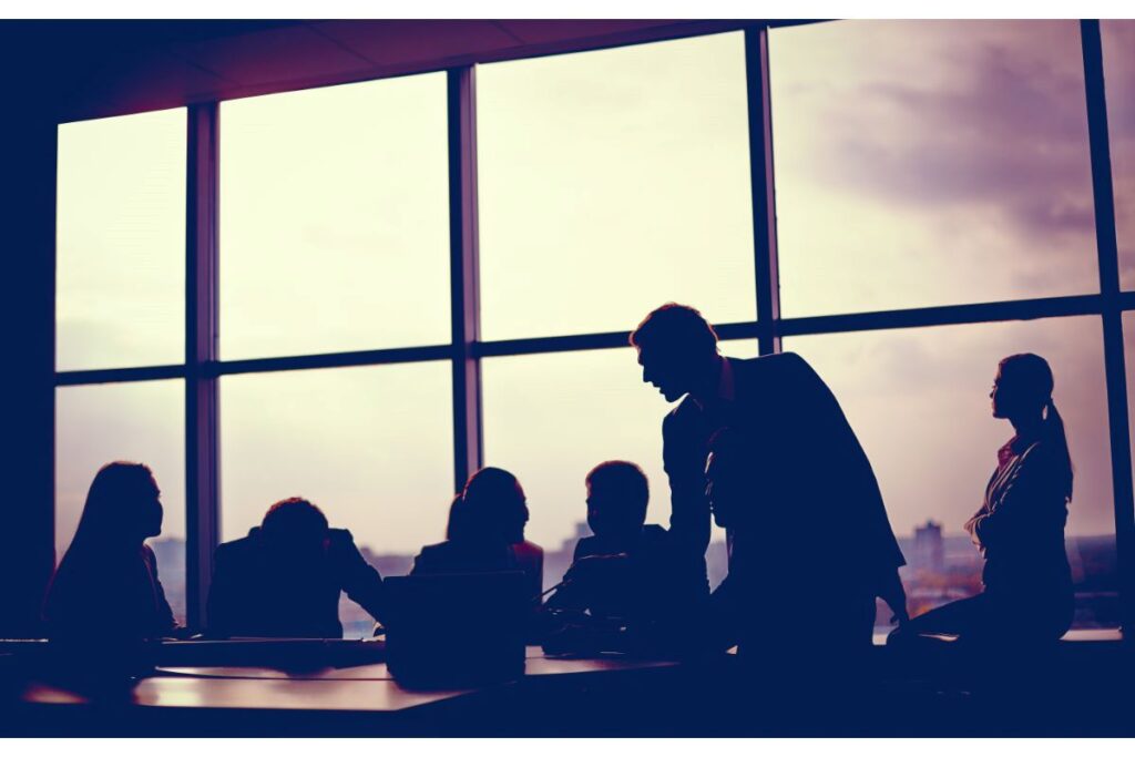 Silhouette of executives meeting around a board room table
